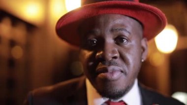 Afrikalı işadamı gece yarısı şapkasıyla dans ediyor.