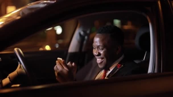 Afrikanischer erfolgreicher Geschäftsmann, der im Auto sitzt, gewinnt einen Jackpot — Stockvideo