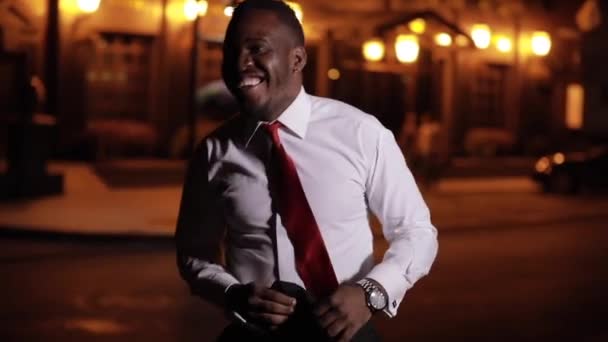 Африканський бізнесмен танцює в нічному місті. — стокове відео