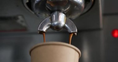 Kahve makineden kağıt bardağa doluyor.