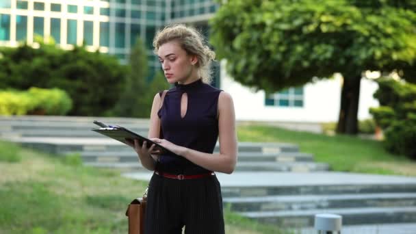 Businesswoman holding folder face o notă — Videoclip de stoc
