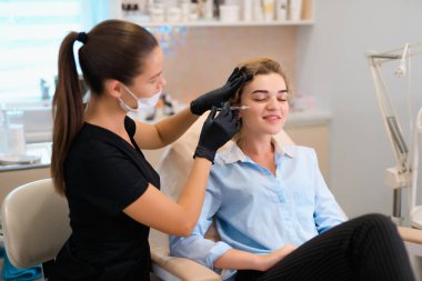 Biorevitalizasyon, güzellik uzmanı güzellik salonunda yüz enjeksiyonu prosedürü uygular.