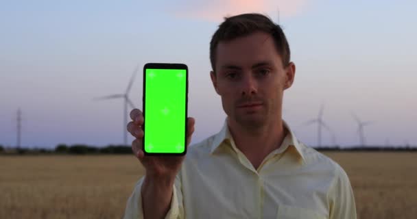 Мужчина показывает смартфон с пустым зеленым экраном — стоковое видео