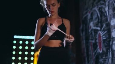 Dişi boksör gece kentinde bandaj sarar.