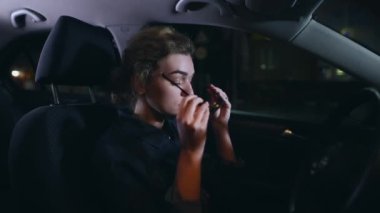 Kadın sürücü iyi bir gece görüşü için sarı gözlük takıyor.