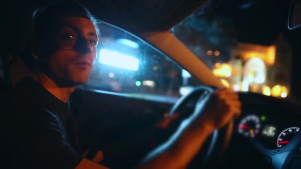 Muž řídí auto v noci — Stock video
