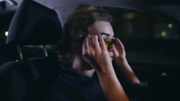 Kobieta kierowca przymierzyć żółte okulary na dobry noktowizor — Wideo stockowe