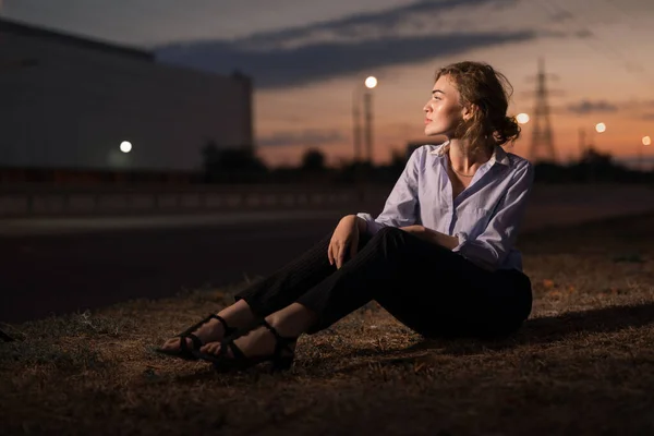 Портрет девушки, сидящей на земле в городе — стоковое фото