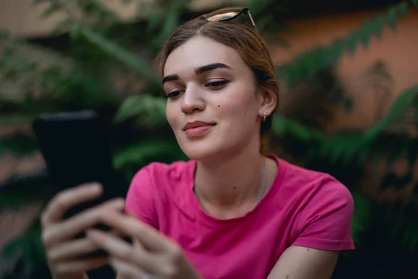 Young woman in pink using smartphone — Stock Photo, Image