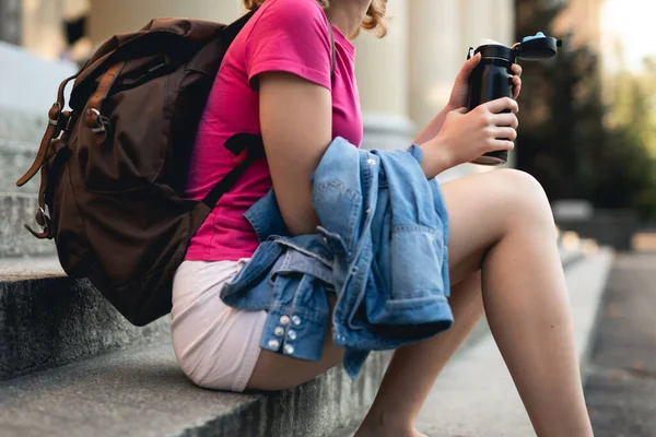 Termosla oturan tanınmayan öğrenci kadın.