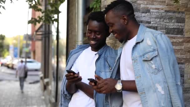 Usmívající se Afričané hledají fotografie ve svých smartphonech — Stock video