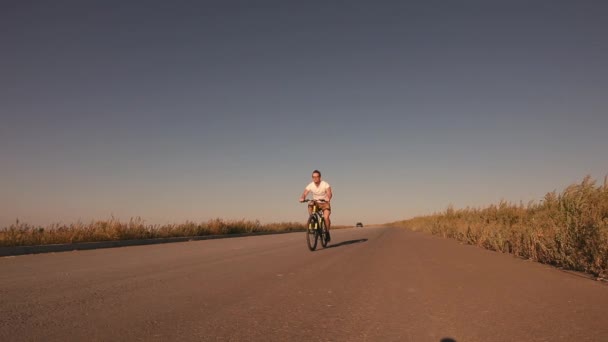 Man rijden fiets op het platteland weg — Stockvideo