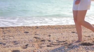 Deniz kıyısına giden kadın bacakları.