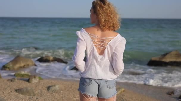 Back view of woman looks at the ocean — Stock Video