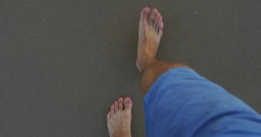 Erkek bacakları kumsalda aşığına gidiyor.