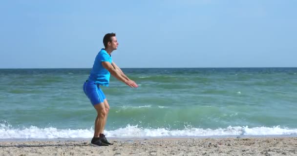 Anak muda melakukan latihan lompat di pantai laut — Stok Video