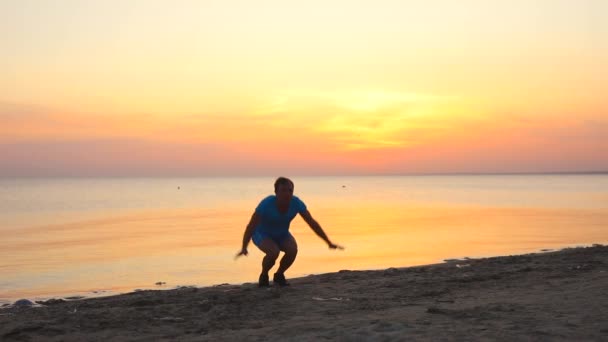 Giovane che fa esercizio burpees al tramonto mare spiaggia al rallentatore — Video Stock