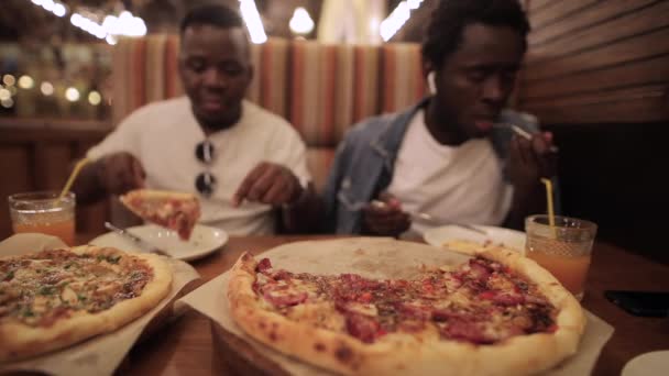 Amis africains manger de la pizza au restaurant — Video