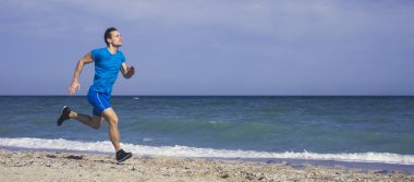 Genç ve hızlı sprinter Okyanus sahilinde koşar