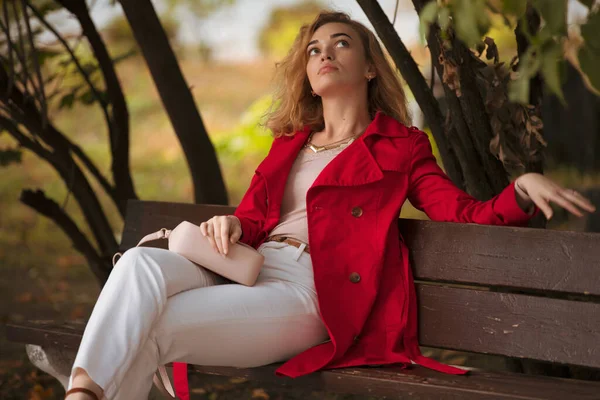 Grimacing Woman Red Coat Sitting Bench Autumn Park — Stock Photo, Image