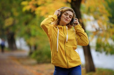 Mutlu kadın sonbahar günü müzik dinler.
