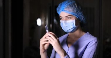 Doktor iğneyi hazırlar şırıngayı elinde tutar.