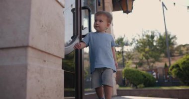 A little boy walks around exploring his backyard
