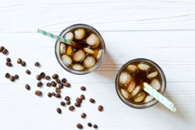 Beyaz ahşap masa üzerinde soğuk bira. Açık renkli buzlu kahve. Üstten görünüm