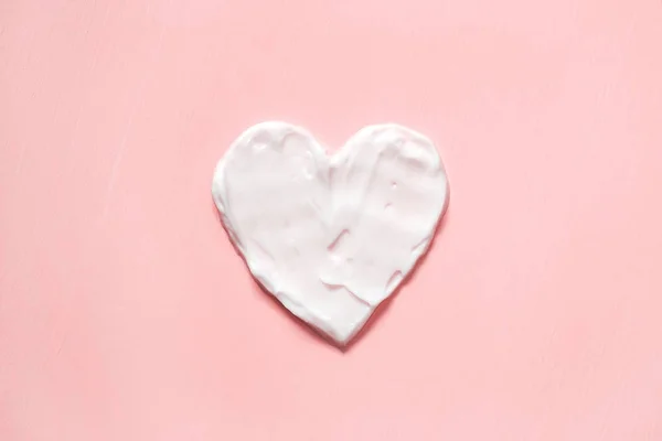 Kalp şekilden krem pembe arka planda. Cilt Bakımı.