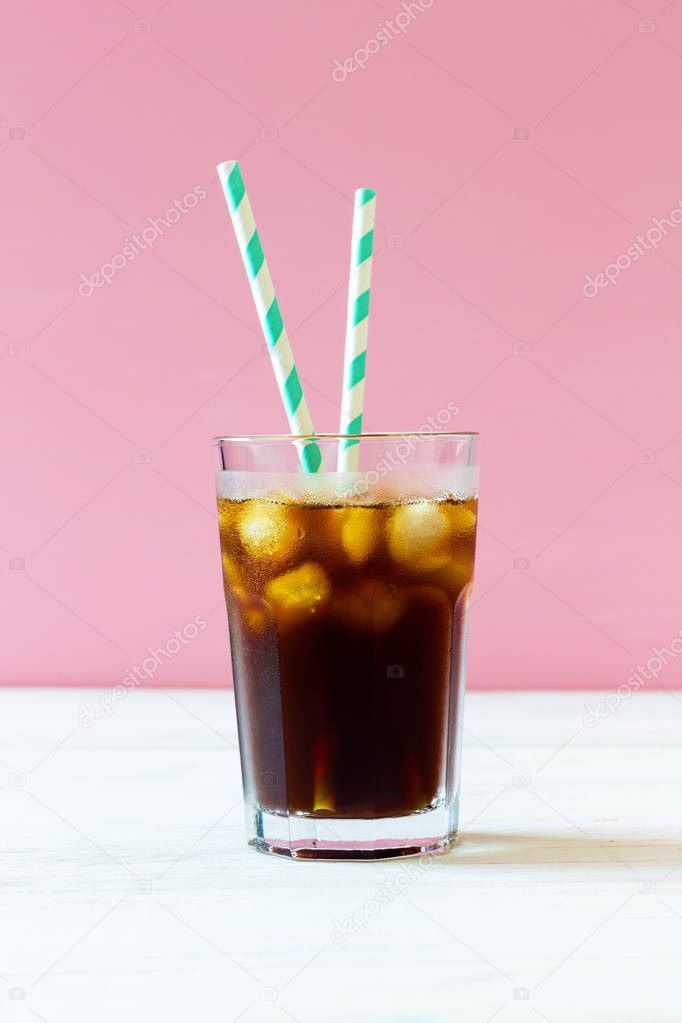 Cold brew. Coffee with ice and striped straws in a glass