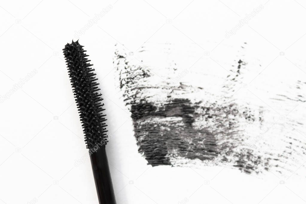 Mascara and make-up brush on white background