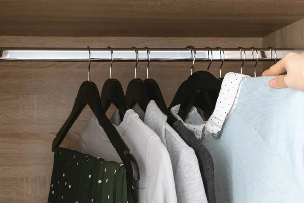 Female hand hangs clothes in wardrobe — Stock Photo, Image