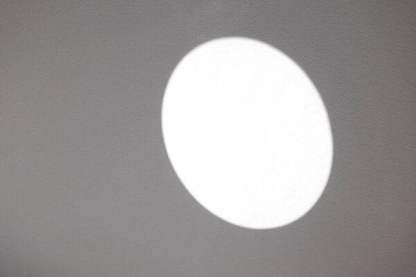 The reflection of the sun on a gray wall