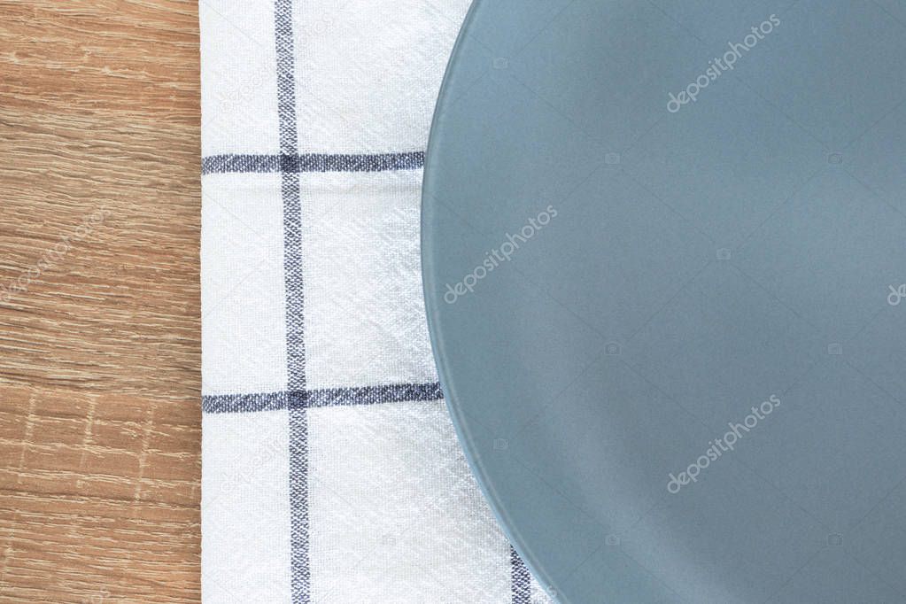 Close-up empty gray plate and white textile napkin