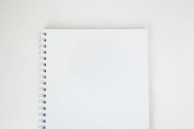Beyaz masa üzerinde spiral ile beyaz boş kağıt defter, üst görünüm. 