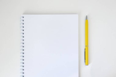 Beyaz spiral bağlayıcı ve sarı kalem ile açık not defteri kadar mock 
