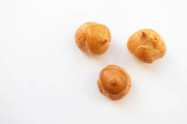 Beyaz arka planda profiteroles, üst görünüm. Kremalı puf kek, cl