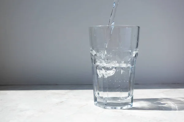 Mineralwasser im Glas auf weißem Steintisch — Stockfoto