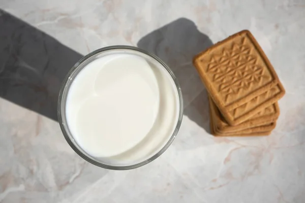 Vista superior de vaso lleno de leche y unos pocos shortbread en una luz m —  Fotos de Stock