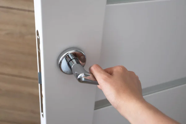 Kadın el yatak odasında kapı açma metal kapı kolu iterek,