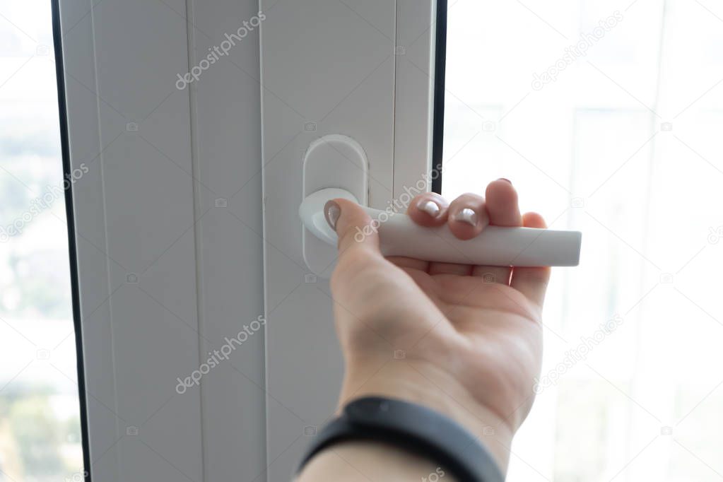 Female hand open plastic pvc white window to get some air, close
