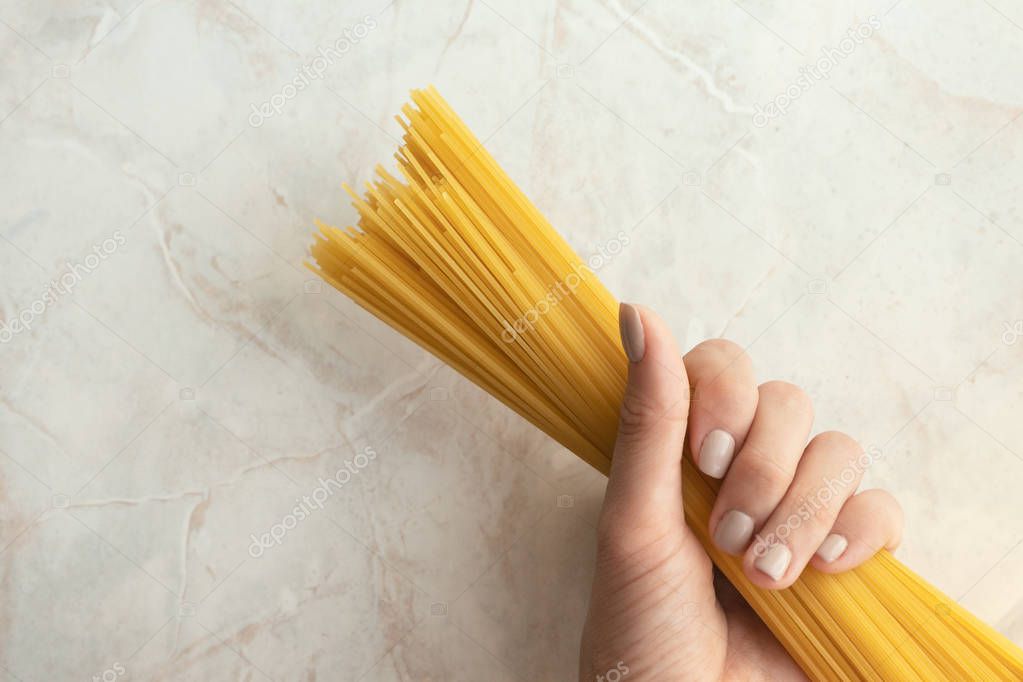 Woman holding long spaghetti ready to cook. Ingredient for Itali
