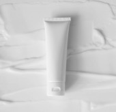 Mockup fehér műanyag cső hidratáló, testápoló, arc tisztító vagy sampon elmosódott krém textúra háttér felülnézet. Finom tisztaságú bőrápoló termék
