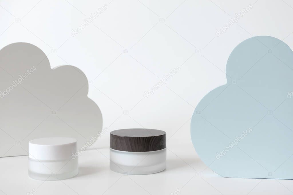 Sensitive rejuvenating eye and facial cream and blue white clouds decor on white background. Concept skincare moisture
