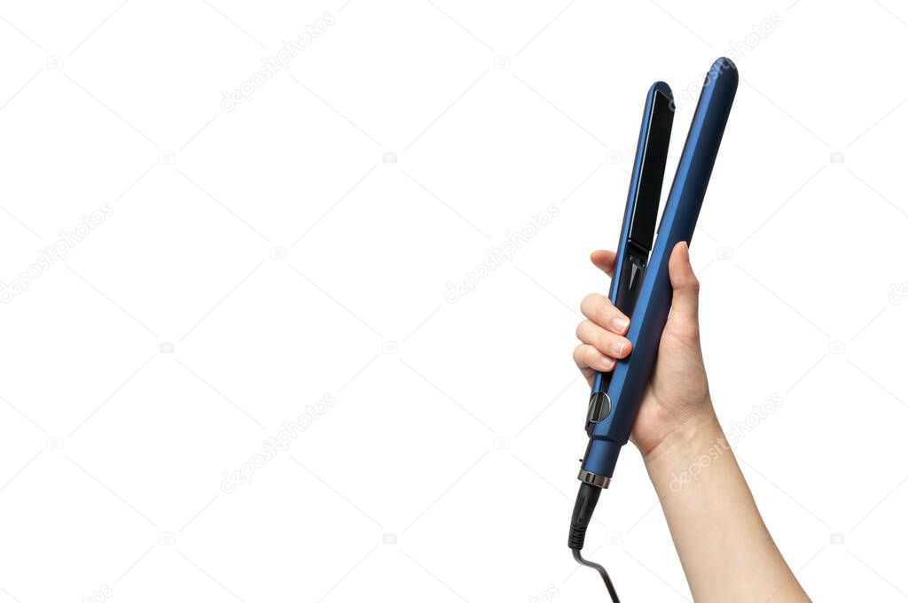 Woman hand holding straightening iron for hairstyle isolated on white background with copy space, horizontal. Haircare concept 