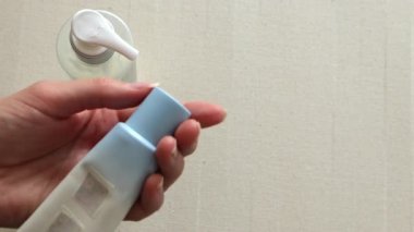 Female hands opening moisturizer cream tube. Minimalist beauty concept self-care, daily skincare routine, wellness