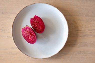 Seramik tabakta dikenli armut kaktüsü meyvesi. Canlı pembe posalı taze tropikal meyve. Besin ve antioksidan, sağlıklı beslenme, egzotik yiyecekler, vegan ve organik yaşam tarzları.
