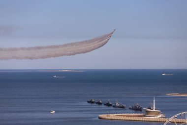 Baku. Azerbaijan. 05.06.2022. Fighter jets fly over the sea, releasing a trail of smoke behind them.