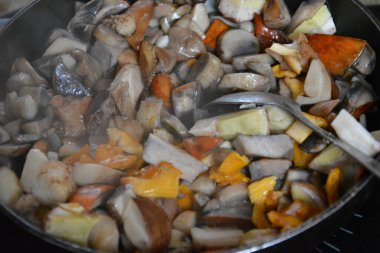 Orman mantarları tavada kızartılır. Sıcak bir buhar var..