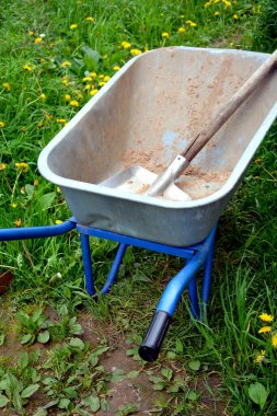 Araba ve kepçe yakın çekim. Kum, kil, turba, humus ve toprak taşımak için bir cihaz. Bahçe, bahçe ve kulübe için tekerlekler üzerinde bahçe aletleri.